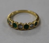 An 18ct gold, emerald and diamond set seven stone half hoop ring, size O.