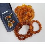 Assorted amber jewellery including necklaces, bracelet, pendant and earrings.