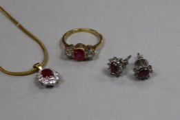 An 18ct gold and platinum ruby and diamond three stone ring, a ruby and diamond cluster pendant on a