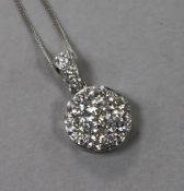 A modern 18ct white gold and seven stone diamond cluster pendant, on an 18ct white gold chain,