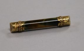A tiger's eye baton brooch with engraved 15ct gold mounts, 50mm.