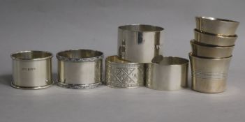 A set of four silver tots, Chester, 1945, four silver napkin rings and an unmarked napkin ring.
