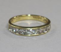 A modern 18ct gold and eleven stone diamond half eternity ring, size N.