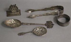 An ornate pair of William IV silver sugar tongs, London, 1834, A Hanau whit emetal spoon, a silver