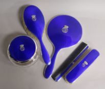 A matched five-piece blue guilloche enamel and silver dressing table set, comprising a hand