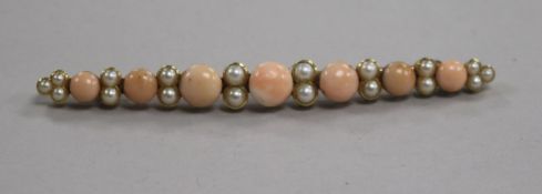 A yellow metal, coral and split pearl tapering bar brooch, 83mm.