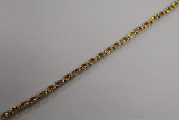 A 9ct gold, citrine and diamond set line bracelet. 19cm.