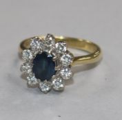 A modern 18ct gold, sapphire and diamond oval cluster ring, size K.