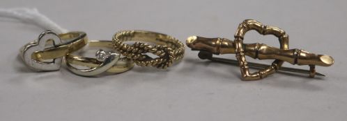 Three 9ct gold rings, one set with a small diamond and a 9ct gold 'heart and bamboo' bar brooch