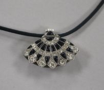 An Art Deco style white metal, diamond and black onyx set fan shaped pendant watch, on a fabric