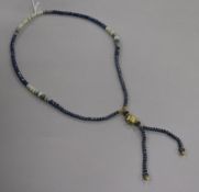 A white opal and facet cut sapphire bead drop tassel necklace with yellow metal spacers and