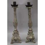 A pair of Renaissance style carved and silvered wood candlesticks, the tapered stems with knop,