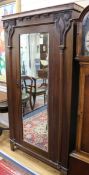 An Edwardian Art Nouveau oak single wardrobe, with mirrored door, flanked by carved tulip panels W.