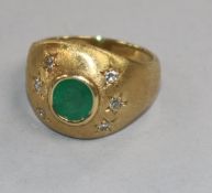 A textured yellow metal, collet set emerald and gypsy set diamond dress ring, size O.