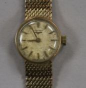 A lady's 9ct gold Longines manual wind wrist watch, on a 9ct gold Longines bracelet, with Longines