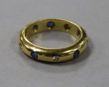 An 18ct gold, gypsy set sapphire and diamond "eternity" ring, size M.