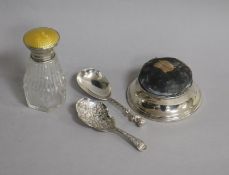 A George V silver mounted pin cushion, two Victorian silver caddy spoons and a silver and enamel