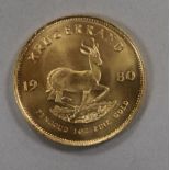 A 1980 gold Krugerand, in plastic coin wallet