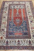 A Persian ivory and red ground prayer rug 210cm. x 130cm.