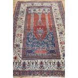 A Persian ivory and red ground prayer rug 210cm. x 130cm.