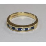 A modern 18ct gold and nine stone sapphire and diamond half hoop ring, size N.