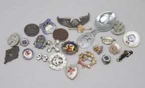 A yellow metal badge and other assorted badges