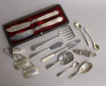 A cased pair of Victorian silver butter knives and twelve other silver items including, wine labels,