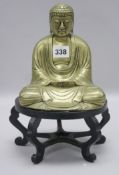 A Chinese brass figure of a seated Buddha, early 20th century, wood stand