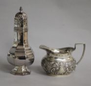 A late Victorian repousse silver cream jug and a later silver sugar caster, 8.5 oz.