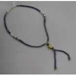 A white opal and facet cut sapphire bead drop tassel necklace with yellow metal spacers and