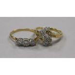 An 18ct gold and three stone diamond ring and an 18ct gold and diamond cluster ring.