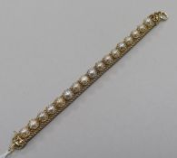 A yellow metal and split pearl set cagework line bracelet. 17.5cm.