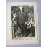 A black and white photograph of Albert Schweitzer standing with two children, apparently dated