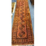 A Persian rust coloured runner, woven with a row of octagons 297 x 85cm.