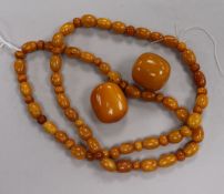 A string of amber beads and two larger loose amber beads, gross weight 78 grams, necklace 78cm.
