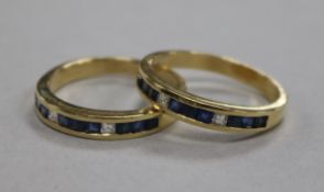A pair of 14ct gold, channel set sapphire and diamond rings, size V.