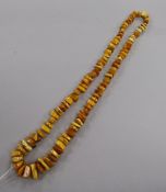 A single strand jagged amber bead necklace and seven loose oval amber beads, gross 81 grams.