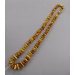 A single strand jagged amber bead necklace and seven loose oval amber beads, gross 81 grams.