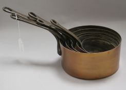 A set of five graduated copper saucepans