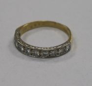 An early 1970's 18ct gold and ten stone diamond half eternity ring, size Q.