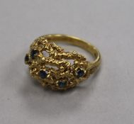 A 1960's 18ct gold and sapphire set pierced 'nugget' ring, size M.
