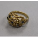 A 1960's 18ct gold and sapphire set pierced 'nugget' ring, size M.