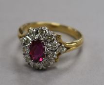 A modern 18ct gold, ruby and diamond oval cluster ring, size K.