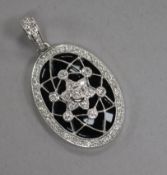 A modern 18ct white gold, black onyx? and diamond set oval pendant, 26mm.