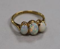 An 18ct gold and three stone white opal ring, size K.