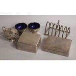 A George V silver three piece condiment set, two silver cigarette boxes and a silver seven bar