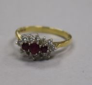 A 1980's 18ct gold ruby and diamond cluster ring, size P.