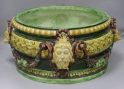 A large majolica circular jardiniere, glazed in green, brown and yellow and applied with mask and