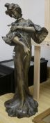 A spelter standing figure of a lady, wearing a flowing robe and holding a flower, H 70cm