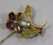 An early 20th century yellow metal and gem set flower brooch, (repairs), 37mm.